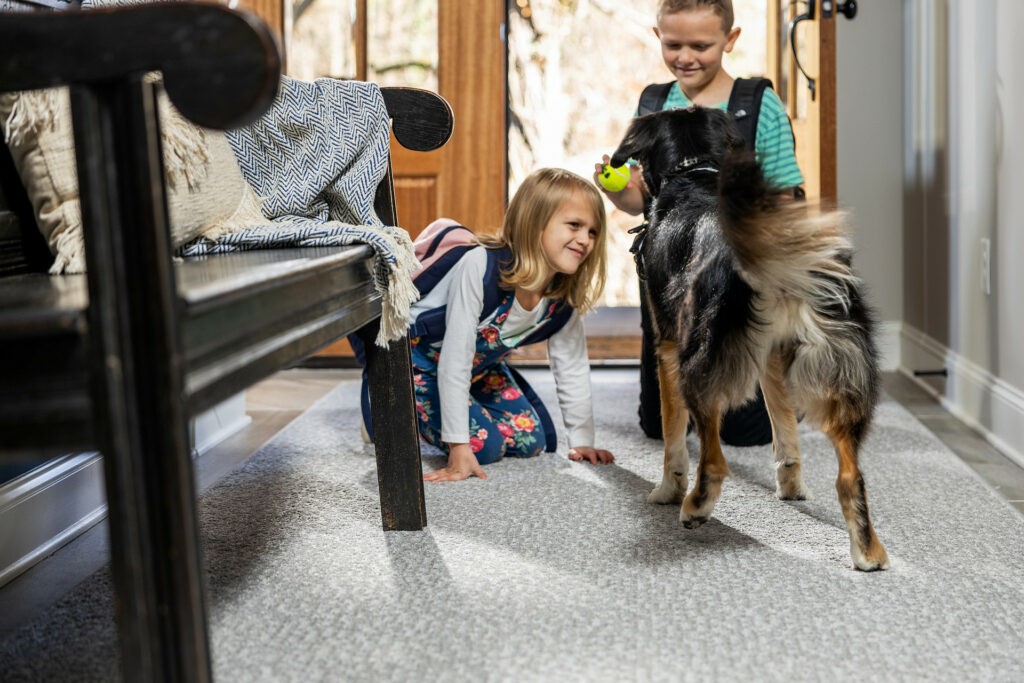 Kids plying with dog on carpet flooring | Floors By Roberts